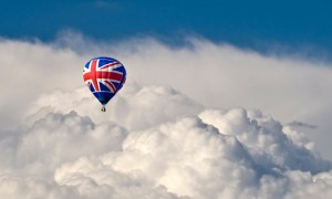 A hot air Balloon with a Union flag motif flying in front of dramatic storm clouds
