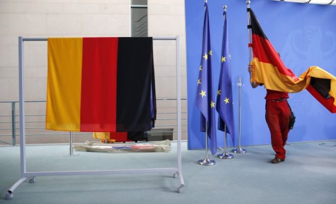 A staff member prepares German flags . REUTERS RTX1RFTQ